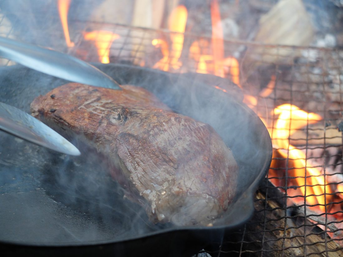 薪火で鹿肉を焼く